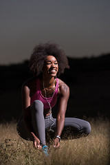 Image showing black woman runner tightening shoe lace