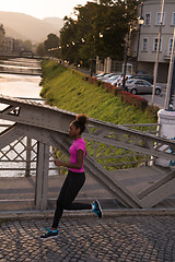 Image showing african american woman running across the bridge