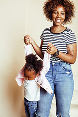 Image showing adorable sweet young afro-american mother with cute little daughter, hanging at home, having fun playing smiling, lifestyle people concept, happy smiling modern family