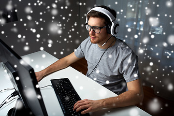 Image showing man in headset playing computer video game at home