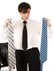 Image showing young brunette handsome guy having choice between two ties isolated on white background, lifestyle business people concept