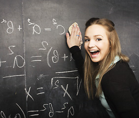 Image showing portrait of happy cute student with book in classroom at blackboard, lifestyle education people concept