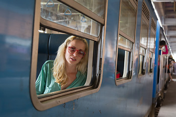 Image showing Blonde caucasian woman riding a train, looking trough window.