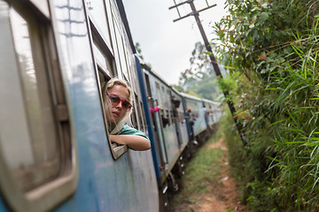 Image showing Blonde caucasian woman riding a train, looking trough window.