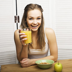 Image showing portrait of happy cute girl with breakfast, green apple and orange juice
