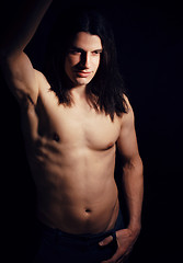 Image showing handsome young man with long hair naked torso on black background