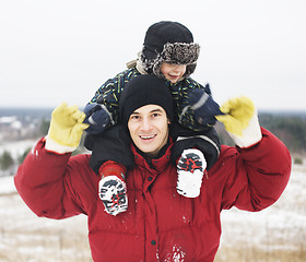 Image showing portrait of happy father with his son outside in winter landscape, lifestyle people concept, real family together