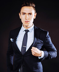 Image showing young pretty business man standing on black background, modern h