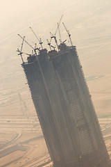 Image showing Skyscrappers construction site with cranes on top of buildings.