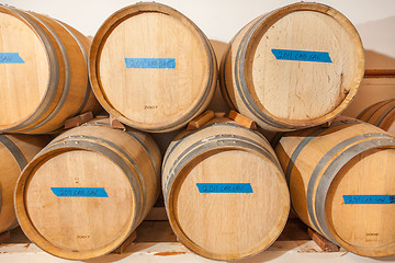 Image showing Wine Barrels and Bottles Age Inside Dark Cellar.