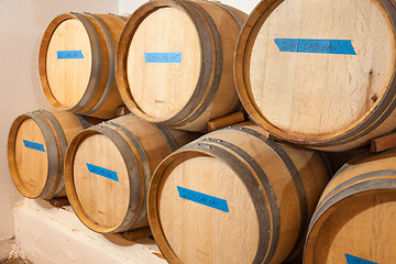 Image showing Wine Barrels and Bottles Age Inside Dark Cellar.