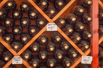 Image showing Several Varietal Wine Bottles Age Inside Cellar