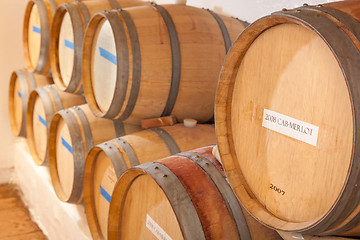 Image showing Wine Barrels and Bottles Age Inside Dark Cellar.