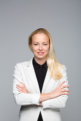 Image showing Business woman standing with arms crossed against gray background.