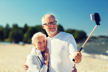 Image showing happy senior couple hugging on summer beach