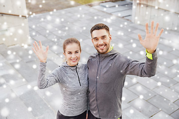 Image showing couple of sportsmen waving hands outdoors in city