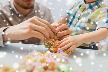 Image showing father and son playing with ball clay at home