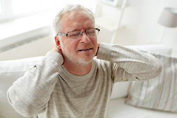 Image showing senior man suffering from neckache at home