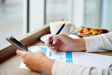 Image showing woman with smartphone and chart at cafe