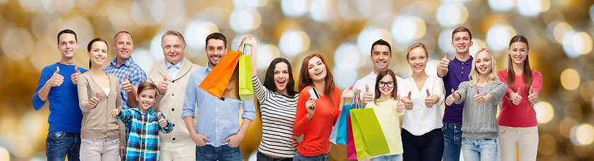 Image showing happy people with shopping bags showing thumbs up