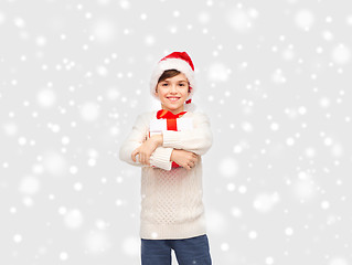 Image showing smiling happy boy in santa hat with gift box