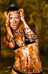 Image showing amazing shot of a young beautiful brunette with her naked body covered of sweet cream chocolate