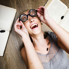 Image showing portrait of crazy student girl in glasses with books and cockroaches, concept of modern education people, lifestyle portrait in interior