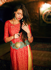 Image showing young pretty asian girl in bright colored interior on carpet view