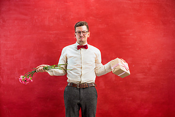 Image showing Young young funny man with flowers and gift