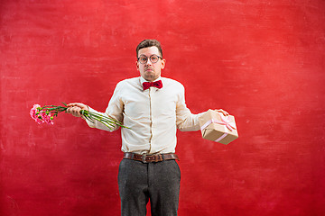 Image showing Young young funny man with flowers and gift