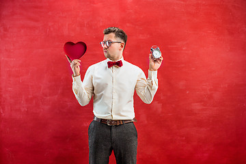 Image showing Young funny man with abstract heart and clock