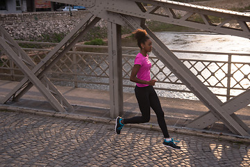 Image showing african american woman running across the bridge