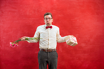 Image showing Young young funny man with flowers and gift