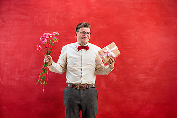 Image showing Young young funny man with flowers and gift