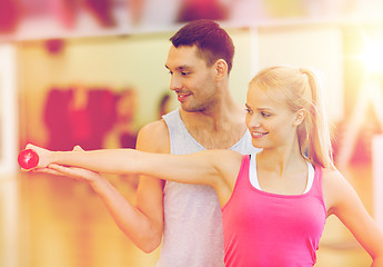 Image showing male trainer with woman working out with dumbbell