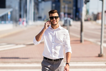 Image showing happy man with smartphone calling on city street