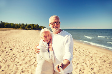 Image showing seniors taking picture with selfie stick on beach