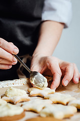 Image showing Person putting a cream to the cookies