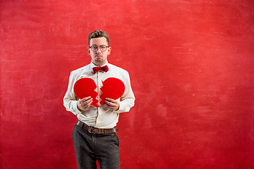 Image showing Young funny man with abstract broken heart and clock