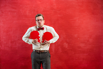 Image showing Young funny man with abstract broken heart and clock