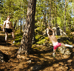 Image showing little cute boy jumping with bungee in forest, training with dad