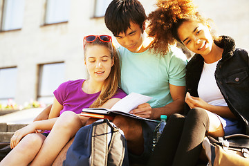 Image showing cute group of teenages at the building of university with books 