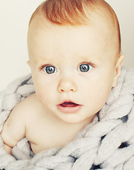Image showing little cute red head baby in scarf all over him close up isolate
