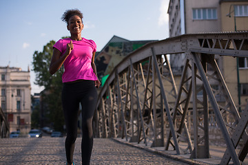 Image showing african american woman running across the bridge