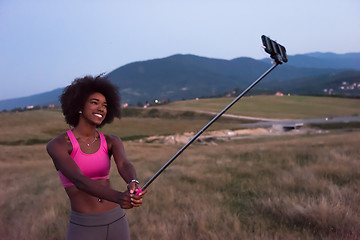 Image showing black woman photographing herself in nature