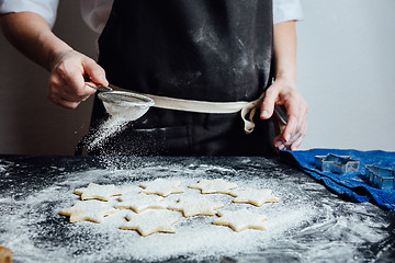 Image showing Person putting raw cookies to flour