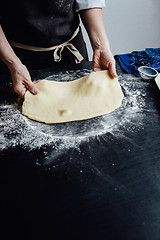 Image showing Person rolling homemade cookie dough