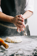 Image showing Person beating up dough with flour