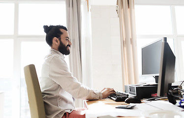 Image showing happy creative male office worker with computer