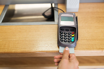 Image showing close up of hand inserting bank card to terminal